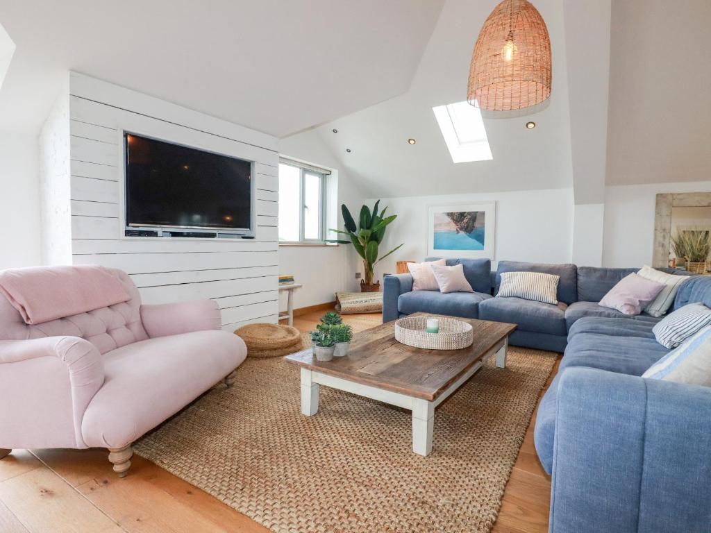 a living room with blue couches and a table at Sea View House in Newquay