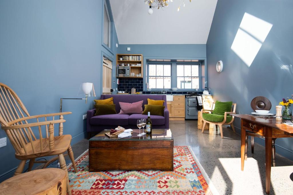 a living room with a purple couch and chairs at Shepherd's Bothy at Papple Steading in East Linton