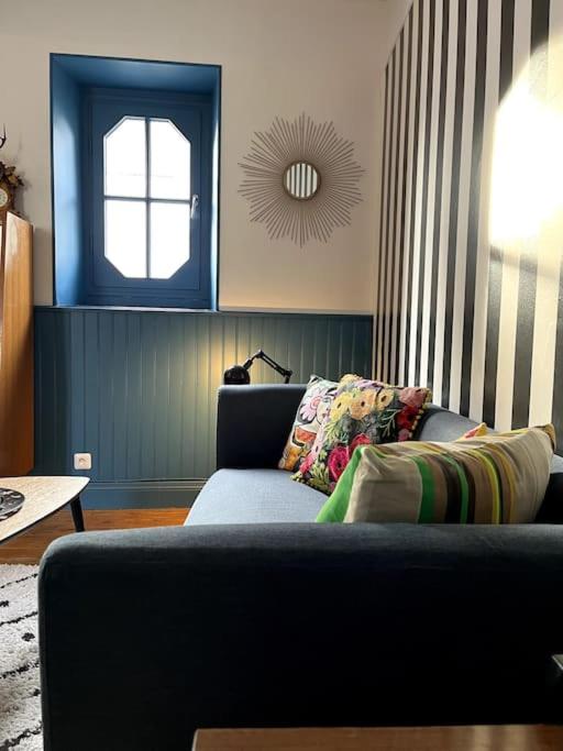 un salon avec un canapé bleu et une fenêtre dans l'établissement L'Atypique d'Orléans, à Orléans