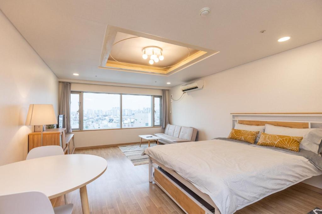 Jiny's Cozy Room في سول: غرفة نوم بسرير كبير وطاولة