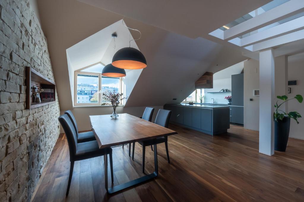 a dining room with a wooden table and chairs at Contemporary Living in the Heart of the City in Ljubljana