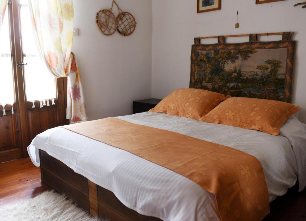 een slaapkamer met een groot bed met een houten hoofdeinde bij ΛΑΓΟΥΜΙ suite Α1 in Elati Trikalon