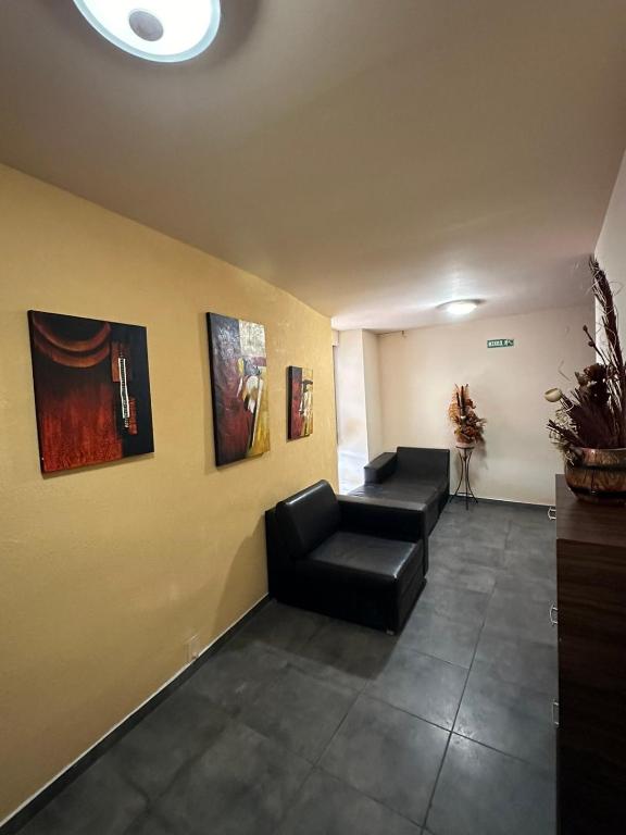 Къща за гости : غرفة انتظار مع أريكة ولوحات على الحائط