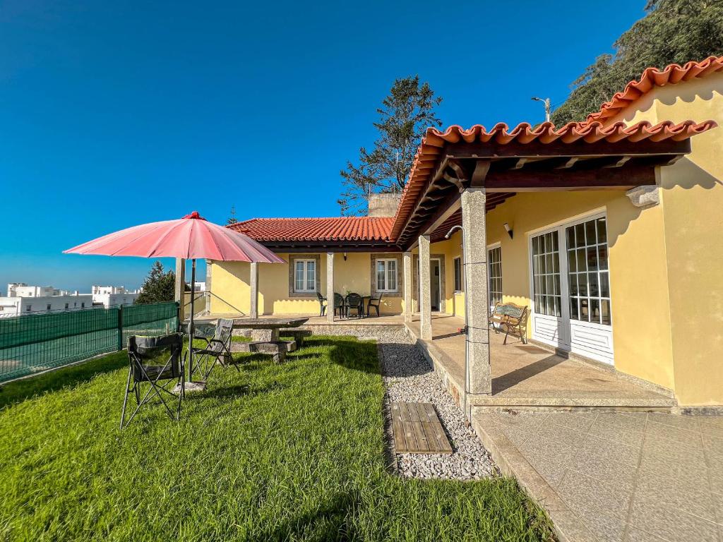 Casa con patio con mesa y sombrilla en Lovely Sunny-House, en Viana do Castelo