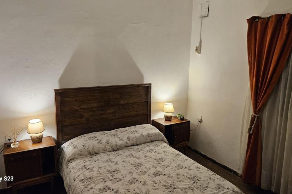 um quarto com uma cama e duas lâmpadas em duas mesas em Apartamento Candombe em Montevidéu