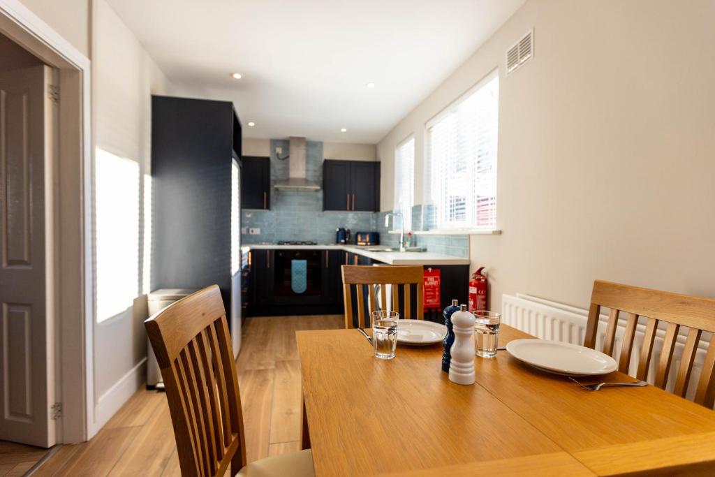 cocina y comedor con mesa de madera y sillas en 68 Glenwood Road, en Ellesmere Port