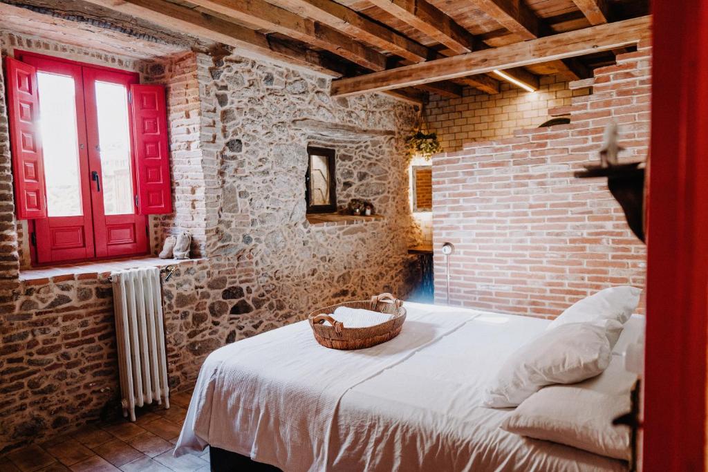 a bedroom with a red door and brick walls at La Casita De Albino in Castillo de Bayuela