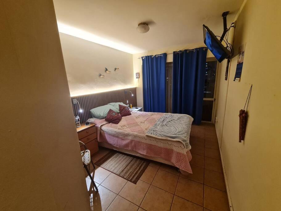 a small bedroom with a bed and a television at Departamento Vina Centro (Portal Álamo) in Viña del Mar