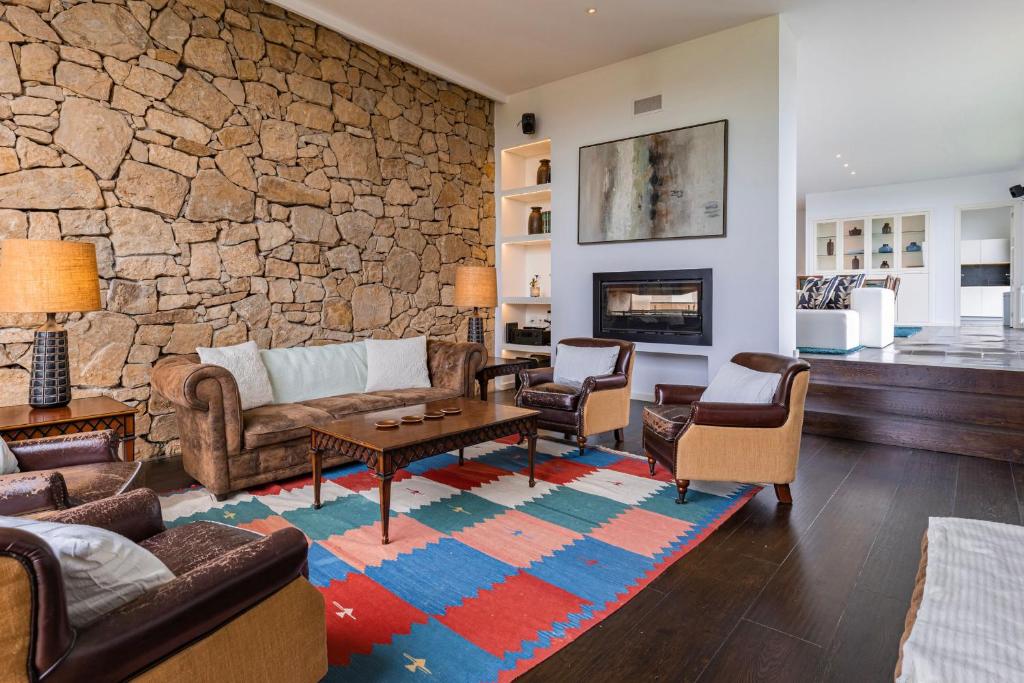 een woonkamer met banken en een stenen muur bij Quinta Casal dos Coxos by LovelyStay in Sobral de Monte Agraço