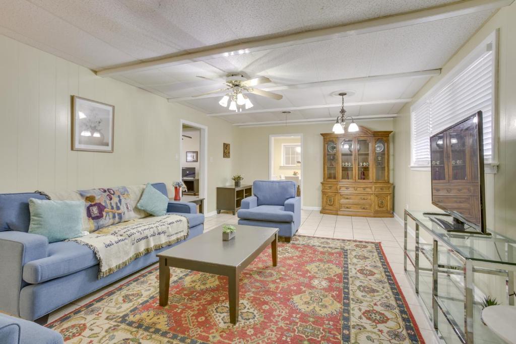 een woonkamer met een blauwe bank en een tafel bij New Orleans Area Home Near the Lake and City Park! in Metairie