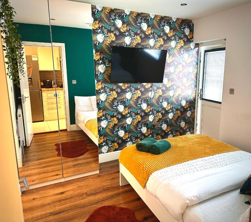 um quarto com uma televisão na parede em Beautiful Studio flat em Purley