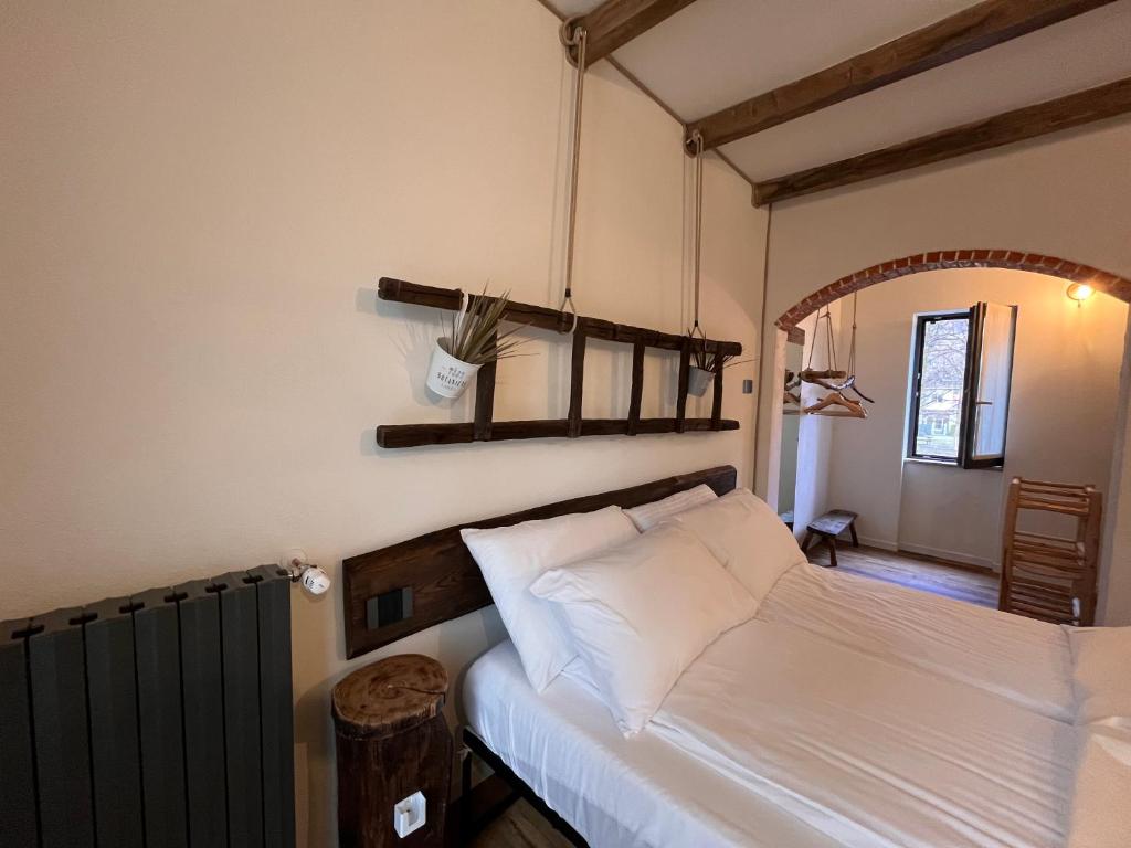 a bedroom with a white bed with a wooden headboard at Stanza in sondrio Coel in Sondrio
