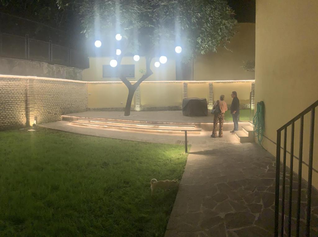 due persone in piedi in un giardino di notte di Rome Bridge Apartment a Roma