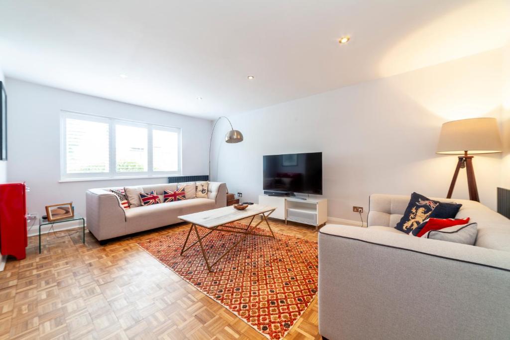 a living room with two couches and a tv at Hidden treasure 2 BR ground floor apt, Brentford in Brentford