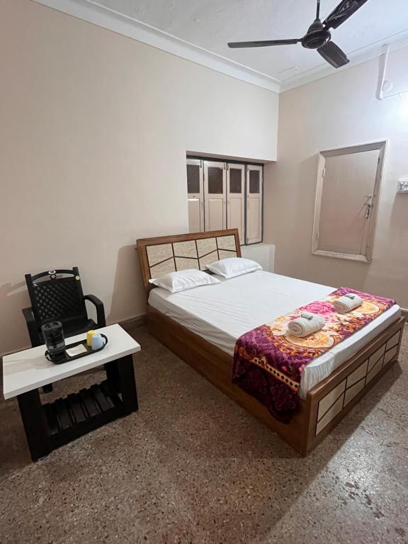 a bedroom with a large bed and a table at Vintage Walls Homestay in Hampi