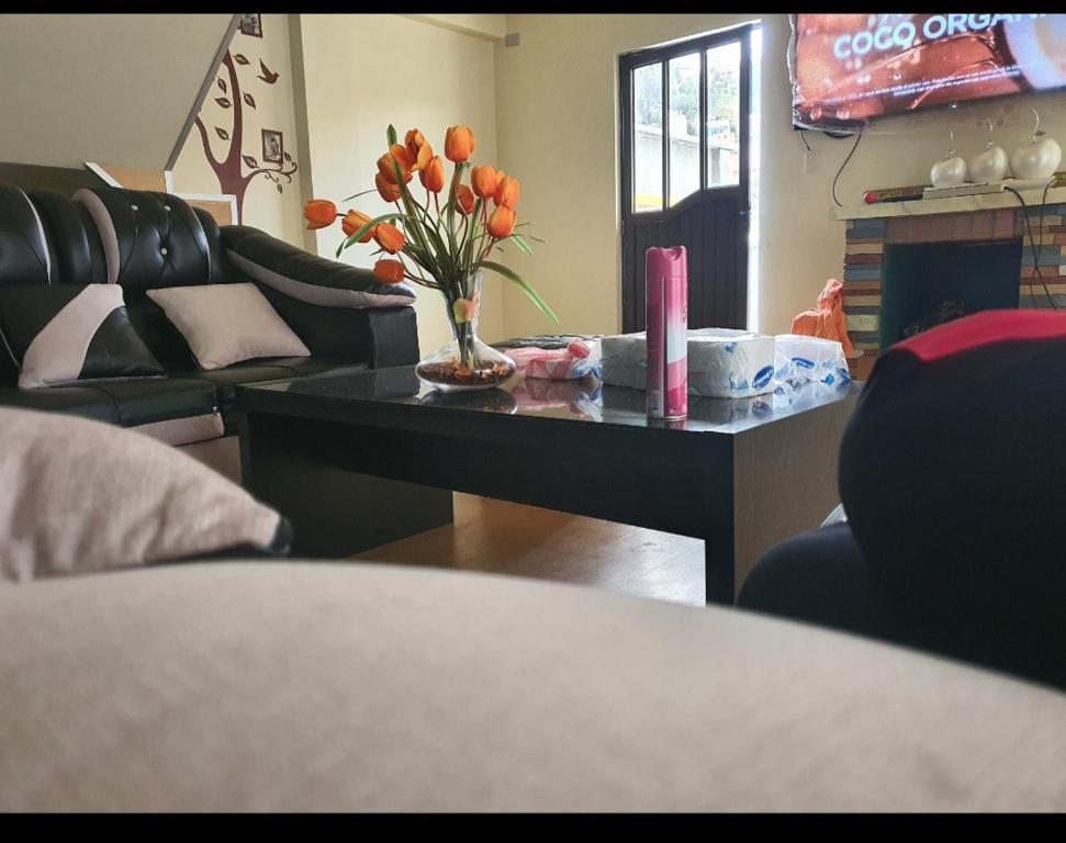 uma sala de estar com uma mesa com um vaso de flores em Departamento Chalet La Portada em La Paz