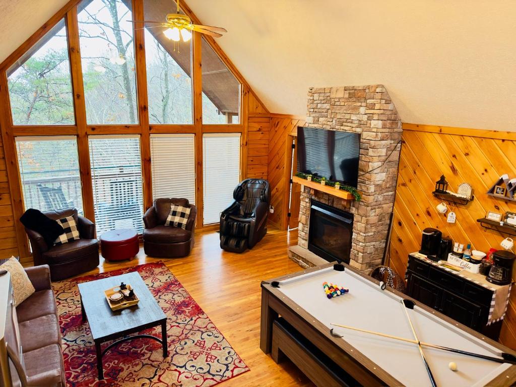 a living room with a pool table and a fireplace at Lazy Bear Den in Sevierville