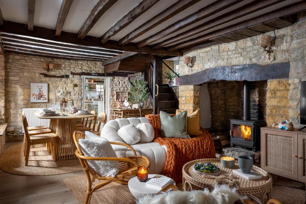 a living room with a couch and a fireplace at Bourton Newly Remodeled Scandi Chic Authentic Charm & Character in Bourton on the Water