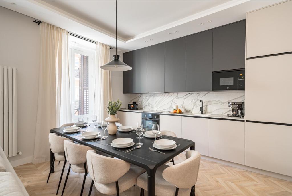 una cucina con tavolo nero e sedie in camera di Luxury flat Centro XVI a Madrid