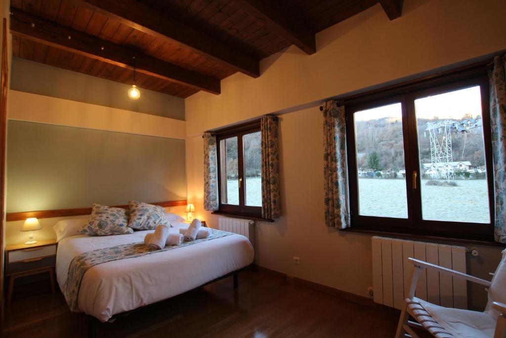 a bedroom with two beds and two windows at Bonita casa de montaña en el Pirineo Central in Escarrilla