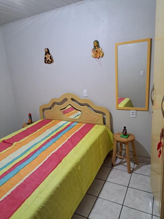 a bedroom with a bed and a mirror at Aconchego no litoral in Barra Velha