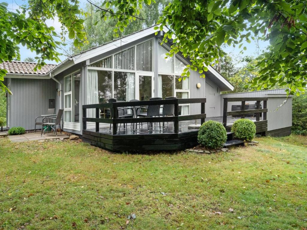 a house with a large screened in porch at Holiday Home Anne - 150m from the sea in SE Jutland by Interhome in Børkop