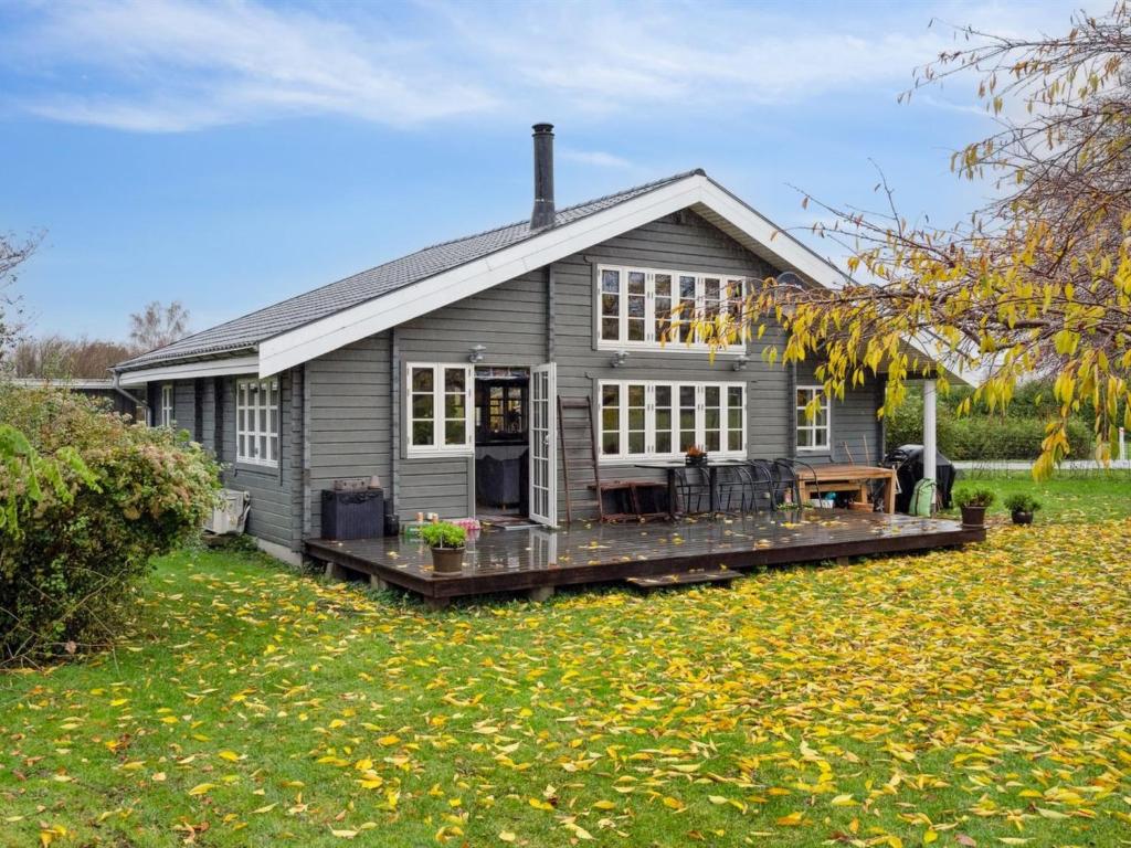 een klein grijs huis met een veranda en een terras bij Holiday Home Anemarie - all inclusive - 400m from the sea by Interhome in Karrebæksminde