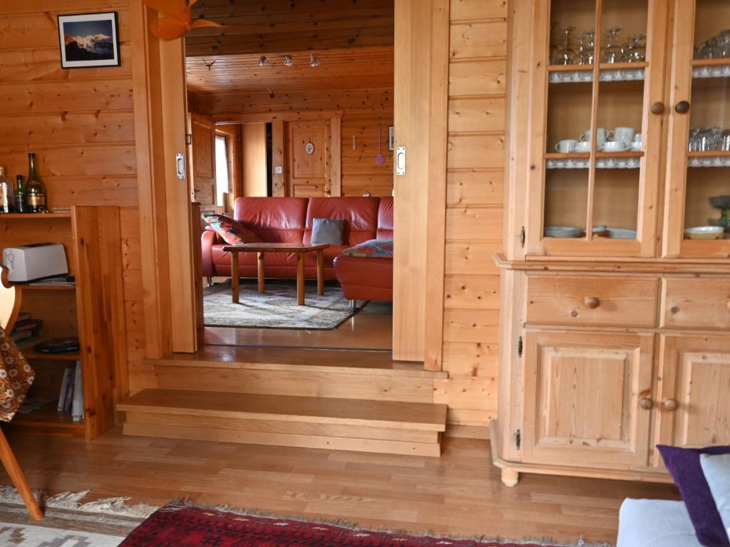 ein Wohnzimmer mit einem roten Sofa und einem Schrank in der Unterkunft Chalet Kil-Ukru by Interhome in Ovronnaz