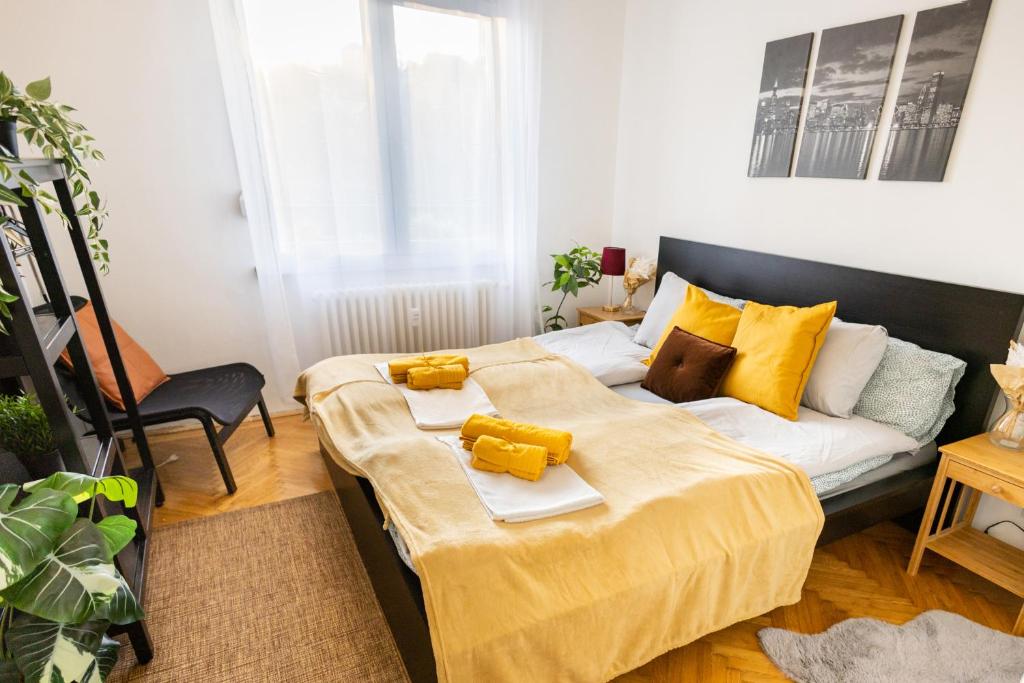 a bedroom with a bed with a yellow blanket on it at Cozy Panorama Apartment next to the Buda Castle in Budapest