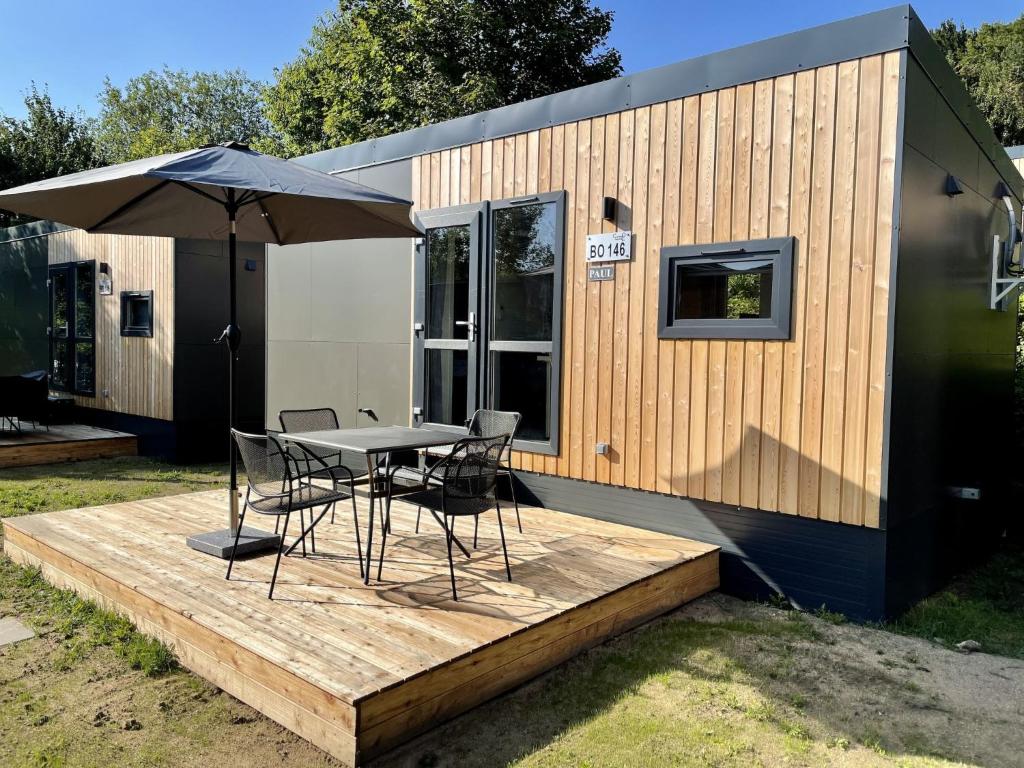 a tiny house with a table and chairs on a deck at Holiday Home Paul by Interhome in Wemding