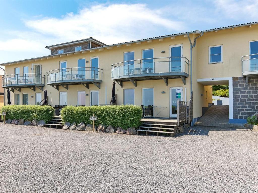 un gran edificio amarillo con balcones y arbustos en Apartment Henna - 50m from the sea in Bornholm by Interhome, en Allinge