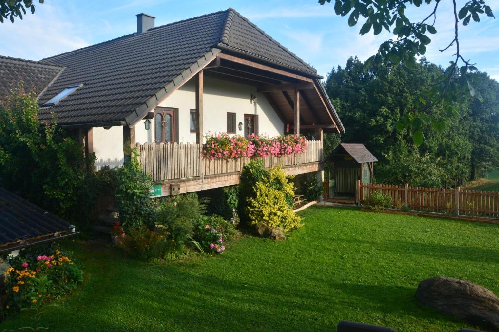 a house with a balcony with flowers in the yard at Bio-Bauernhof Haunschmid in Ardagger Markt