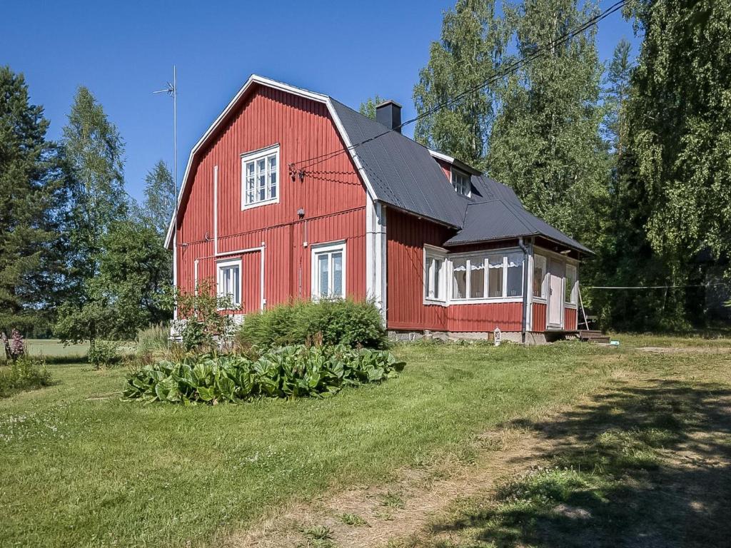 une grange rouge assise au-dessus d'un champ verdoyant et luxuriant dans l'établissement Holiday Home Lehtola by Interhome, à Mäntsälä