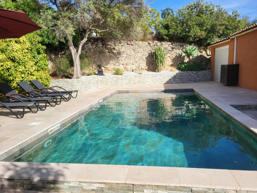 una piscina con sillas y sombrilla en Holiday Home La Maison château vert by Interhome, en Sanary-sur-Mer