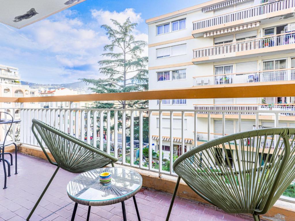 un balcón con sillas y una mesa y un edificio en Apartment Les Arènes de Cimiez by Interhome, en Niza