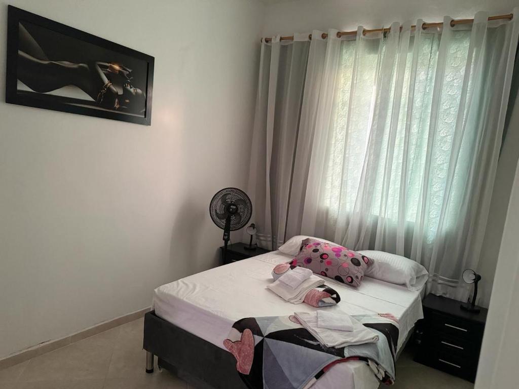 ein kleines Schlafzimmer mit einem Bett und einem Fenster in der Unterkunft Apartamentos ANGEL'S in Buga