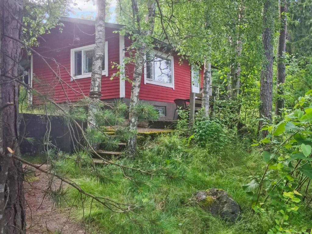 een rood huis in het bos met bomen bij Holiday Home Köningsviken by Interhome in Sipoo