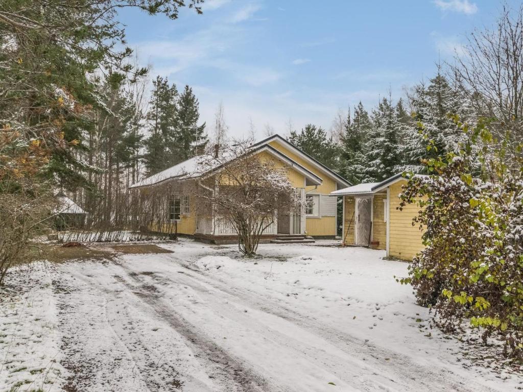 Casa amarilla con entrada cubierta de nieve en Holiday Home Villa heikinniemi by Interhome, en Joutsa