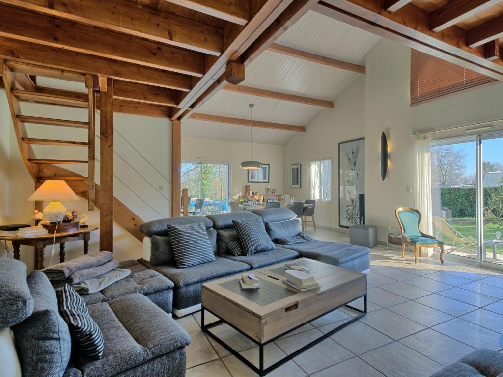 een woonkamer met een blauwe bank en een tafel bij Holiday Home Charme de la Fradinière by Interhome in Saint-Hilaire-de-Riez