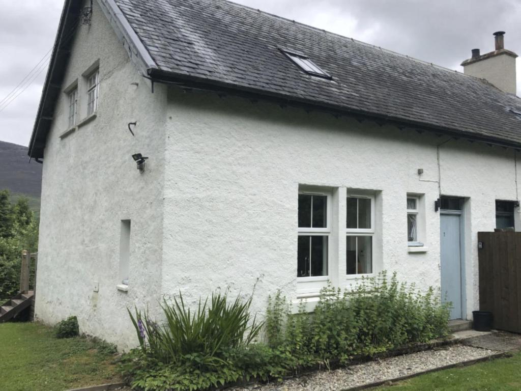 a white house with a black roof at Holiday Home 1 Railway Cottage by Interhome in Aviemore