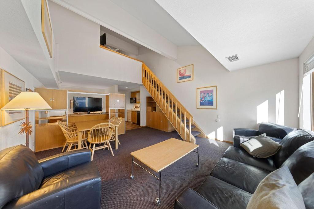 a living room with a couch and a table at Palisades Tahoe Lodge Rentals Studio Loft #314 in Olympic Valley