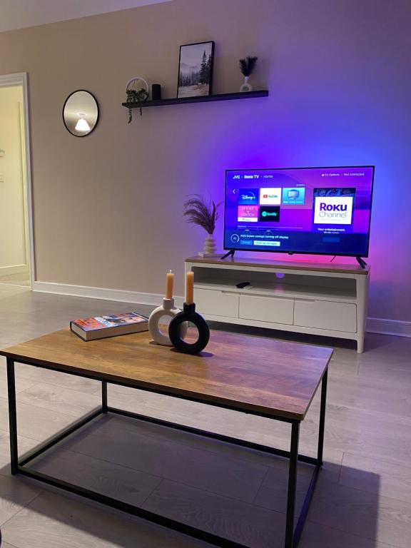 a living room with a tv and a coffee table at Crawley 2bed Apartament close to Gatwick Airport in Copthorne