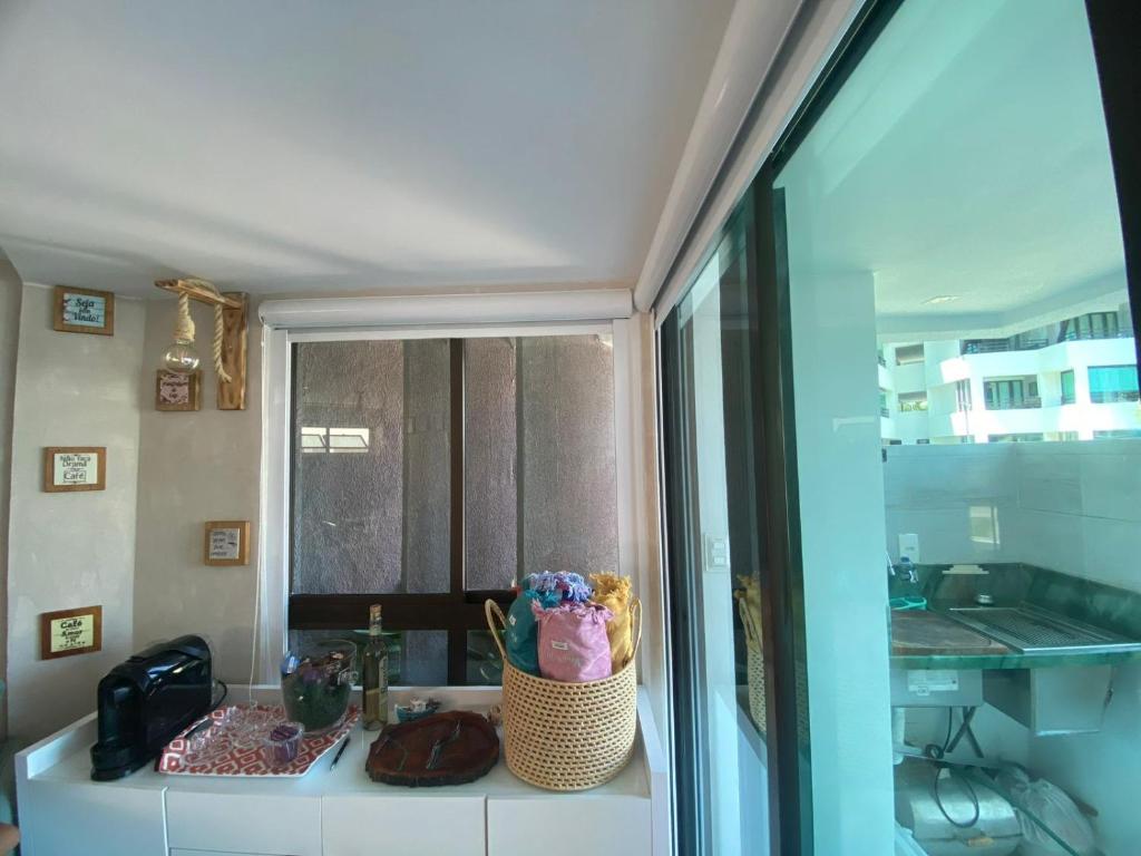 een badkamerbar met een mand met bloemen erop bij FLAT TAMANDARÉ MAUI 01 in Tamandaré