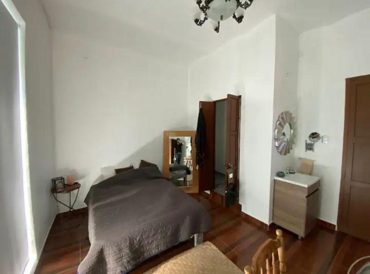 sypialnia z łóżkiem, komodą i lustrem w obiekcie Comoda habitacion con baño privado morelos 1 w mieście Querétaro