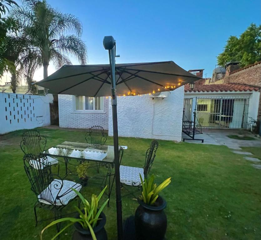 een tafel en stoelen onder een paraplu in een tuin bij Apartamento en Carrasco Sur, cerca del aeropuerto y la rambla in Montevideo