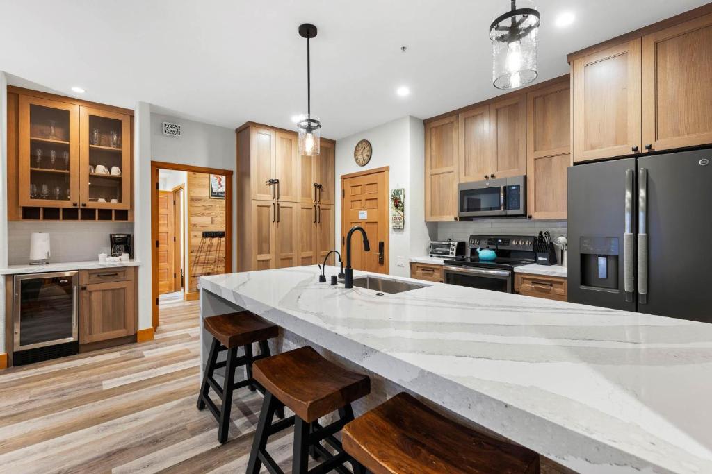 a kitchen with a large white counter top and wooden cabinets at Palisades Tahoe Lodge Rentals Premium Two Bedroom #700 in Olympic Valley