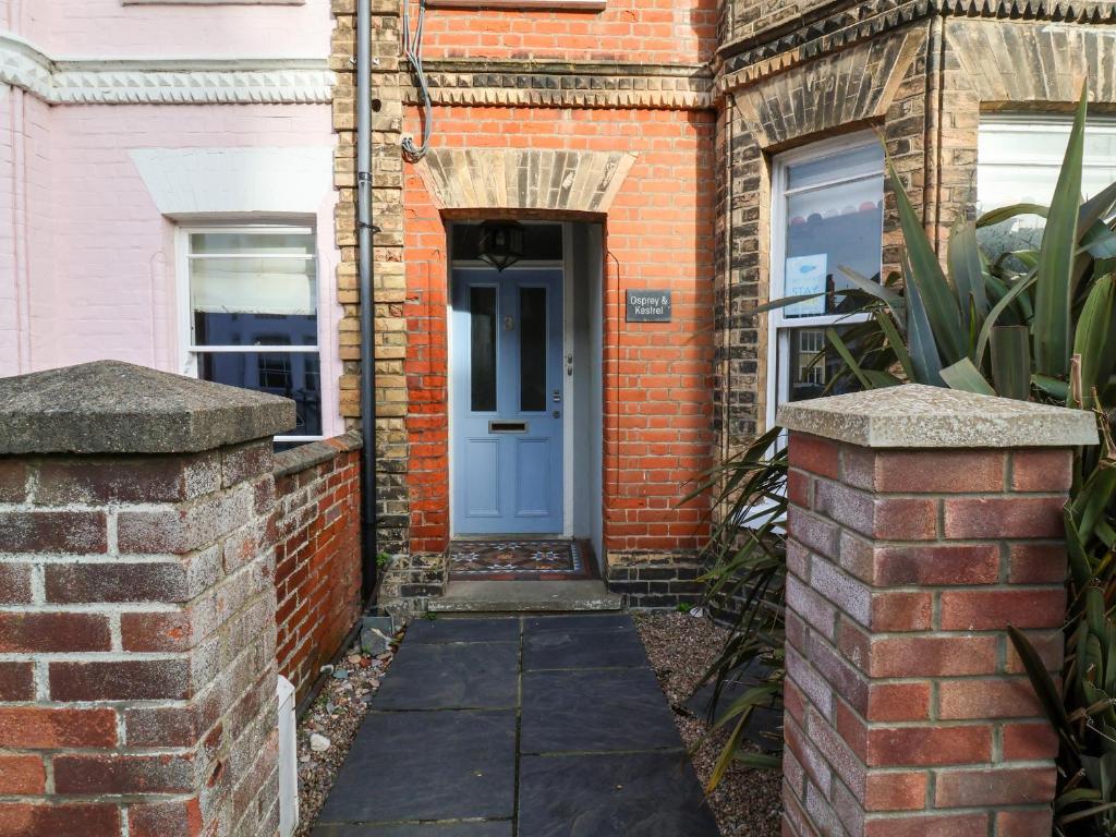 a brick house with a blue door on it at Kestrel in Southwold