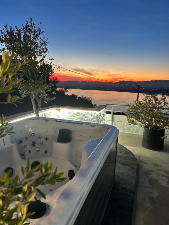 a bath tub on a balcony with a sunset at Appartement Duplex Rosas avec terrasse magnifique jacuzzi vue mer in Roses