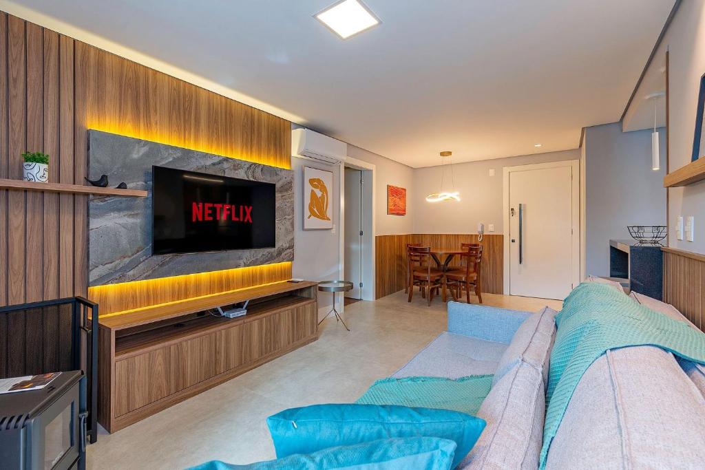 Una sala de estar con un sofá y un televisor. en Ap excelente Caracol - @stayhousetemporada, en Canela