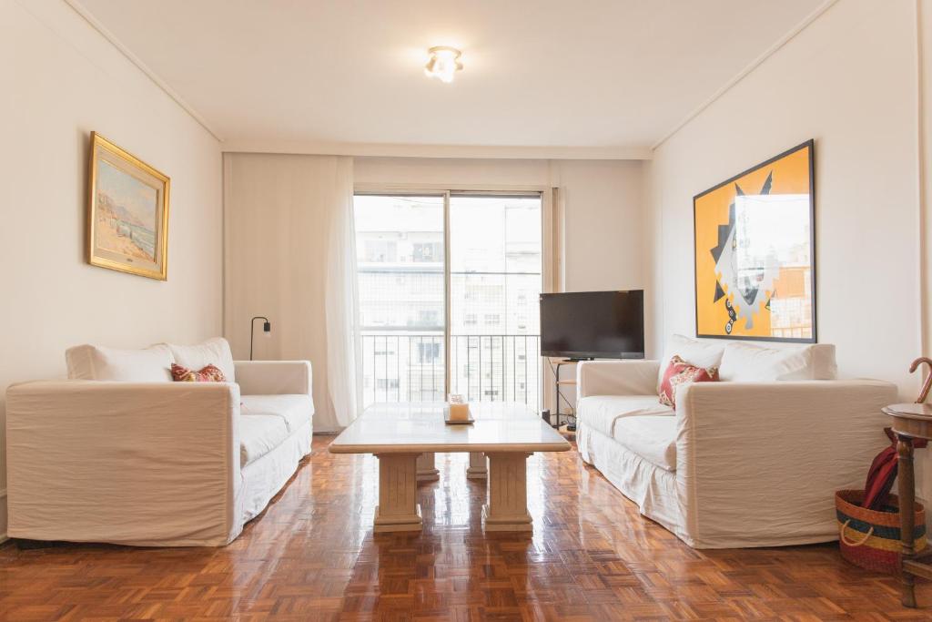 uma sala de estar com dois sofás brancos e uma mesa em Apartment in Recoleta em Buenos Aires